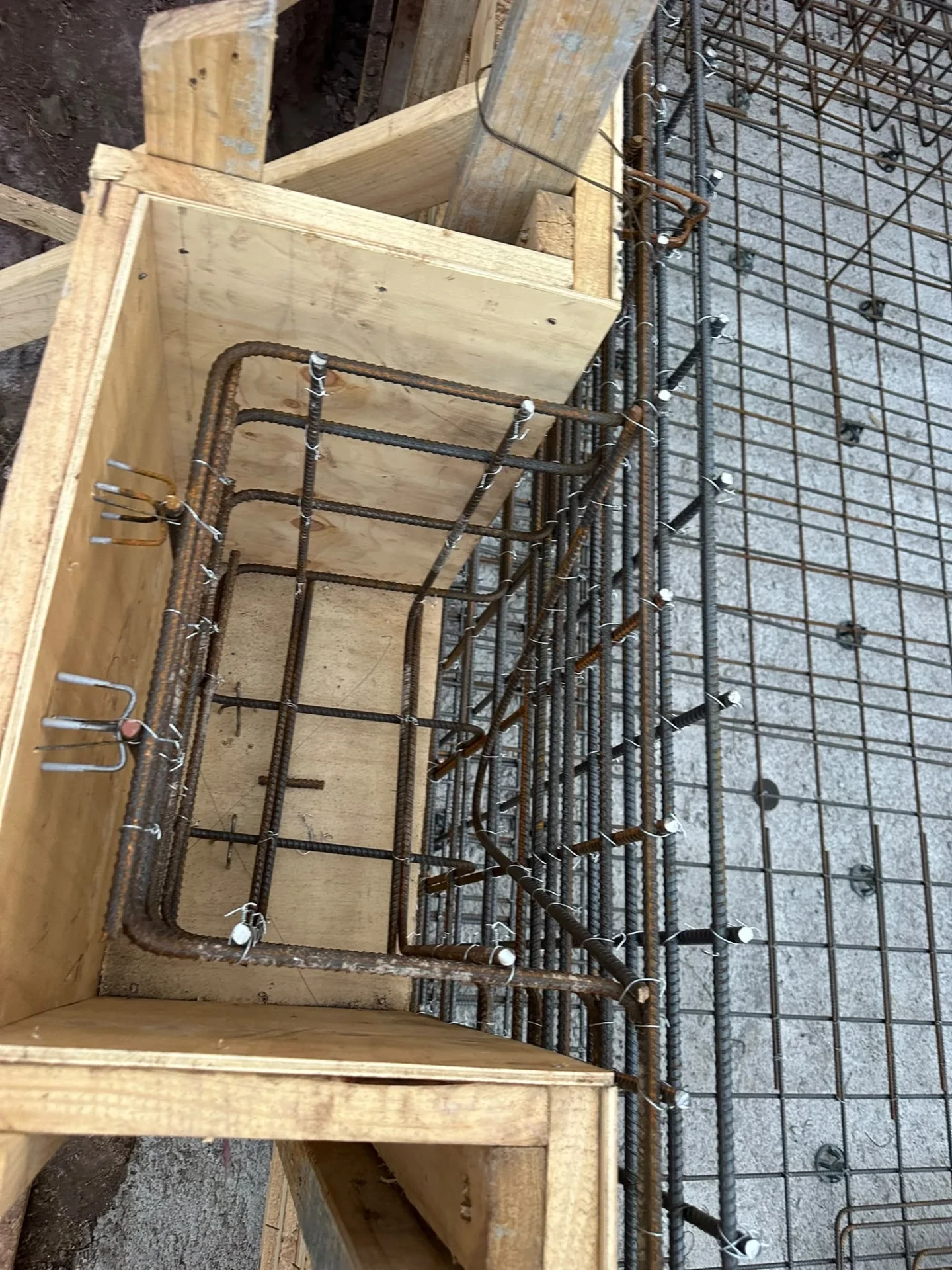 Boxed formwork for a step with tied reinforcement bars connecting into the adjoining pool floor mesh.