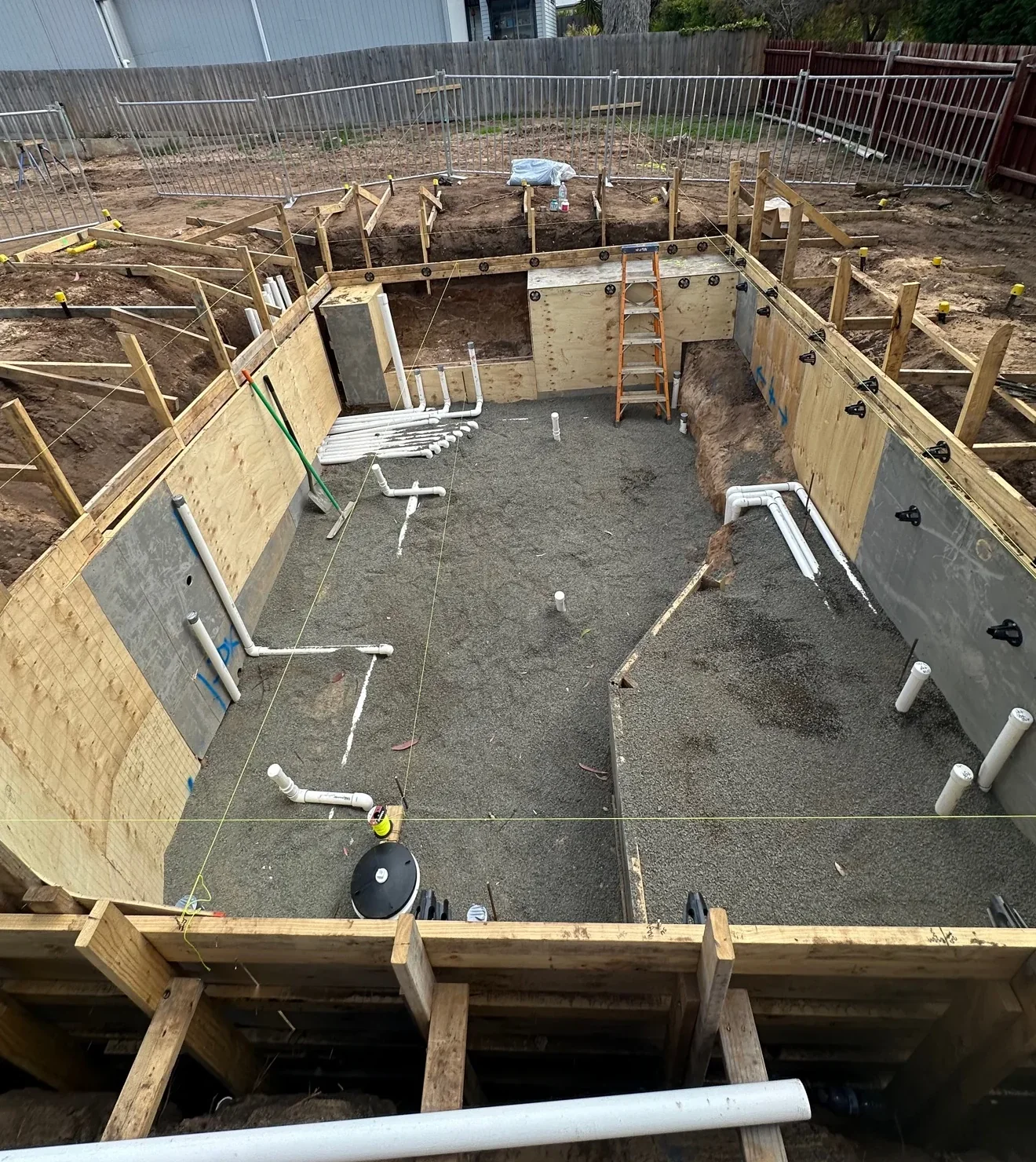 Whole Portsea pool and round-spa footprint with curved formwork and in-shell plumbing before steel fixing.