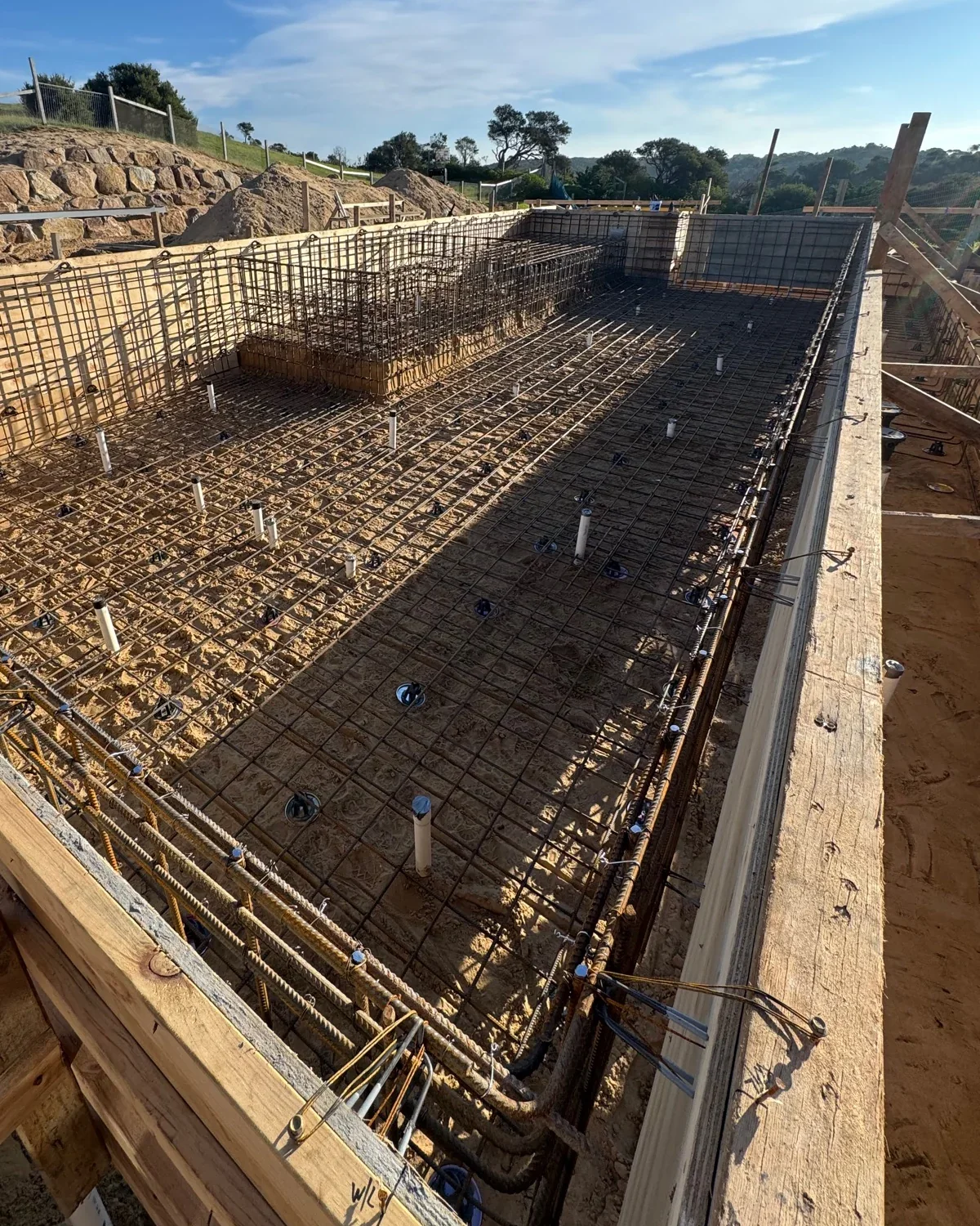 Whole large Portsea pool reinforcement cage with a raised integrated structural zone and in-shell service penetrations.