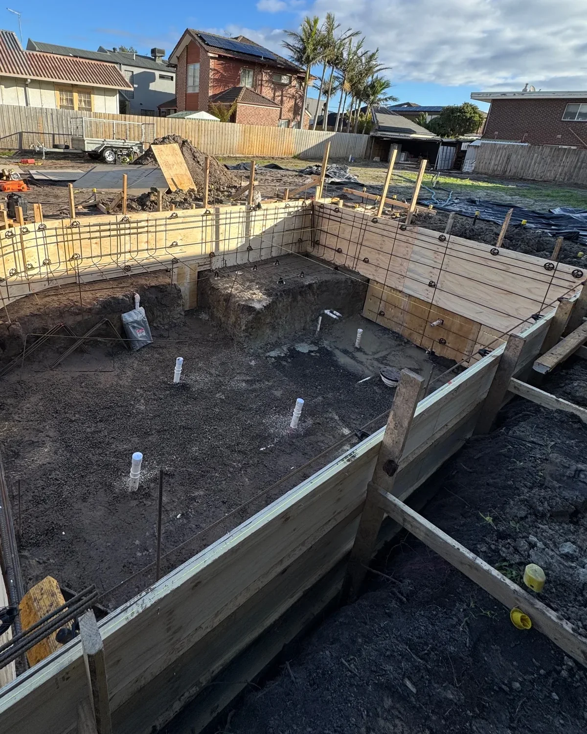 Whole pool formwork with a rounded corner and stepped structural geometry before steel fixing.