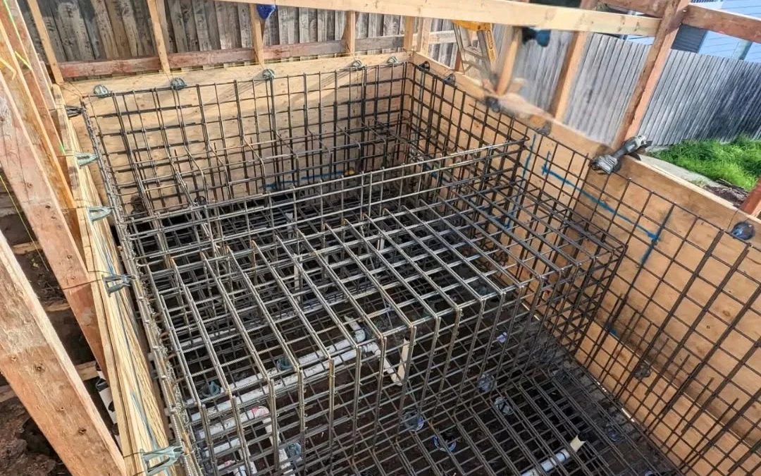 Detailed multi-level reinforcement and in-shell services inside pool formwork in Axedale.